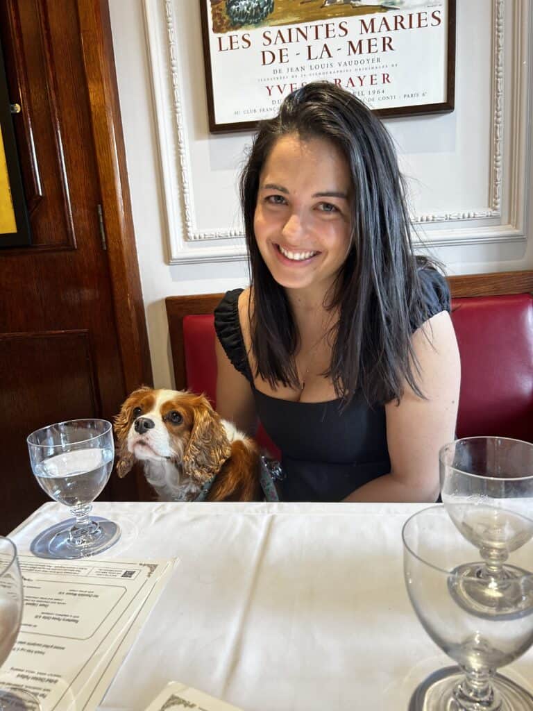 Image of the author and her dog, a cavalier king charles spaniel, at a restaurant